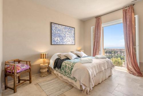 a bedroom with a bed and a large window at Villa du Claoux Superieur in Vence