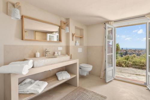 a bathroom with a sink and a toilet and a window at Villa du Claoux Superieur in Vence