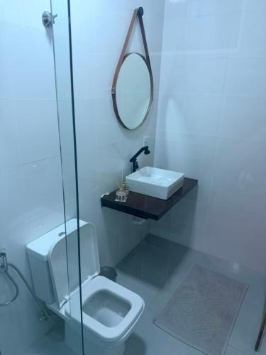 a bathroom with a toilet and a sink and a mirror at O mais charmoso do centro in Sinop