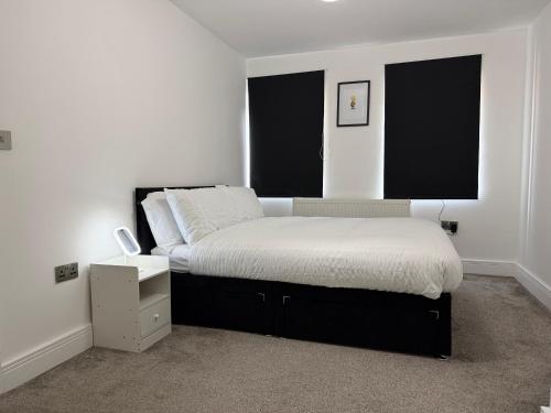 a bedroom with a bed and two windows at Serene 2-BDR Maisonette in Wolverhampton