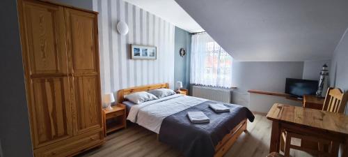 a bedroom with a bed and a large window at Willa Aura in Łeba