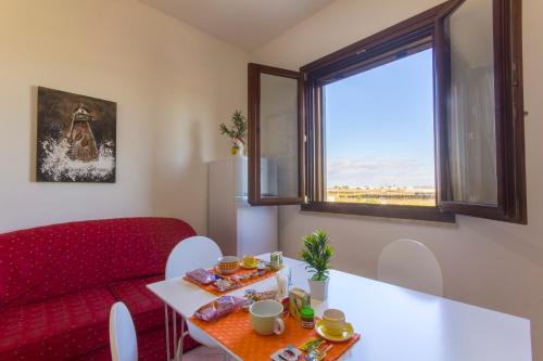 un soggiorno con divano rosso e tavolo di Appartamenti Elios a Birgi Vecchi