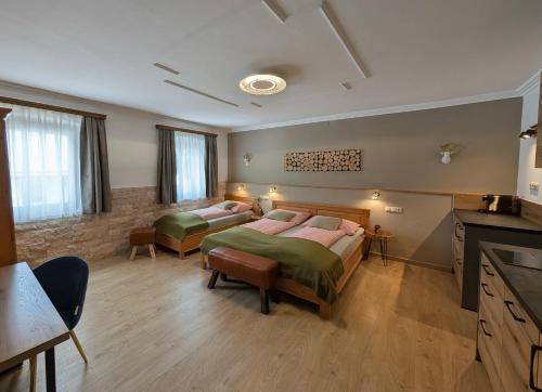 a bedroom with two beds in a room with a kitchen at Hotel Apartment Das Au- Gut in Hallein