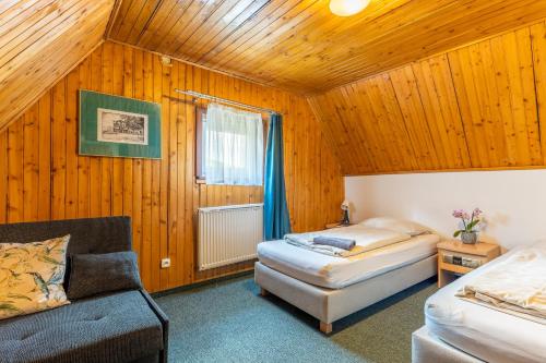 a bedroom with two beds and a couch in a room at Pensjonat Stokłos in Duszniki Zdrój