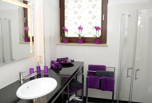 Un baño con lavabo y una ventana con detalles morados. en Bambus, en Leipzig