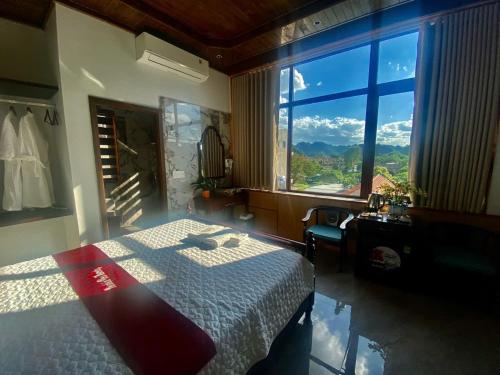 a bedroom with a bed and a large window at Mountainview tam coc villa in Vũ Lâm