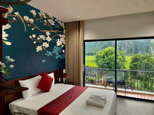 a bedroom with a bed and a large window at Mountainview tam coc villa in Vũ Lâm