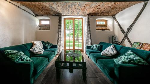 a living room with a green couch and a table at Dom w Gajówce u podnóża Gór Izerskich in Gajowka