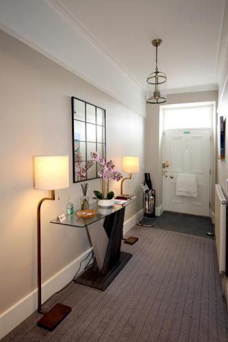 a room with a table and two lamps and a door at No. 41 Town House in Inverness