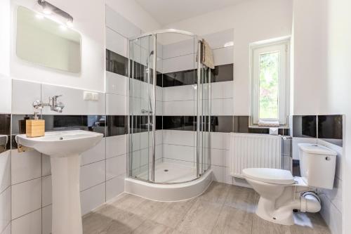 a bathroom with a shower toilet and a sink at Pensjonat Stokłos in Duszniki Zdrój