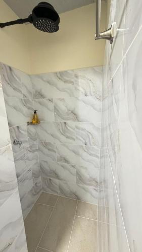 a bathroom with a shower with white marble walls at Comodo aparta estudio en Jerico Antioquia in Jericó