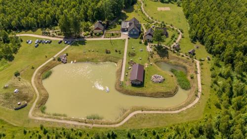 an aerial view of a large house with a pond at Ēmužas in Dārte
