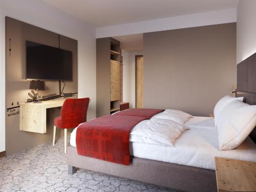 a bedroom with a bed and a desk with a red chair at Hotel & Restaurant Wilder Mann in Aalen