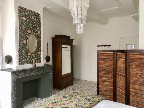 a living room with a fireplace and a mirror at Le Couvent des Ecrevisses in Barjols