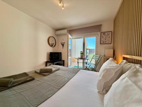 a bedroom with a large white bed and a balcony at IN-Cascais - Suite Deluxe with Terrace & Villa with Pool in Cascais