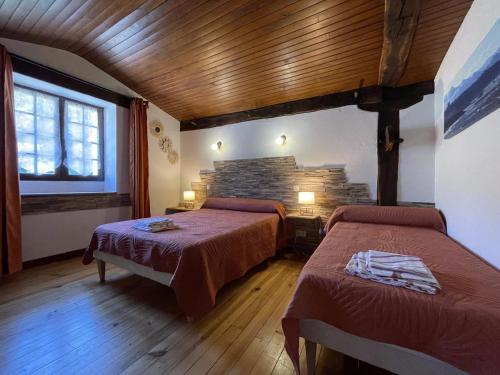 a bedroom with two beds and a brick wall at Sagarra in Saint-Étienne-de-Baïgorry