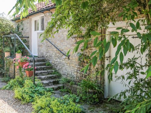 a stone house with stairs leading to a door at Garden Flat in Pilton