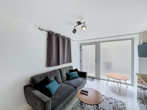 a living room with a couch and a table at Urban Grey - Terrasse - Wifi in Châtellerault