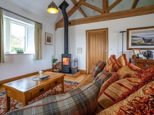 a living room with a couch and a wood stove at The Cottage - Ukc9711 in Winster