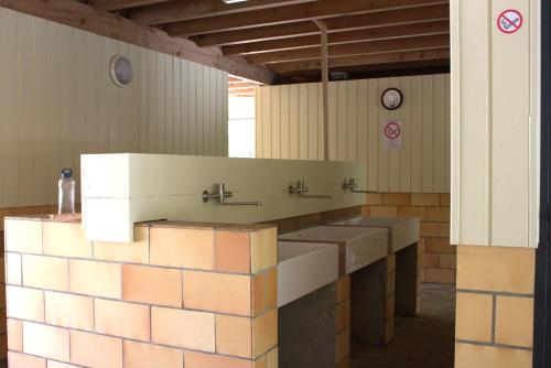 a bathroom with three sinks in a room at Camping Le Capdeville in Carcans