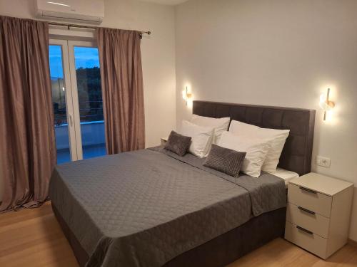 a bedroom with a bed with two pillows and a window at Adriatic Pearl Povile in Povile