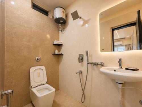 a bathroom with a toilet and a sink and a mirror at Annapurna Prestine Puri - Comfortable Stay Near Jagannath Temple - with Free Wi-fi, Parking, Restaurant in Puri