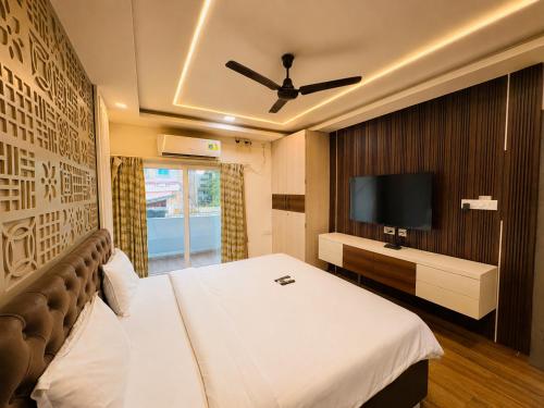 a hotel room with a bed and a flat screen tv at Annapurna Prestine Puri - Comfortable Stay Near Jagannath Temple - with Free Wi-fi, Parking, Restaurant in Puri