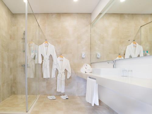 a bathroom with a shower and a sink and a mirror at RIDE Surf Resort & Spa Peniche in Peniche