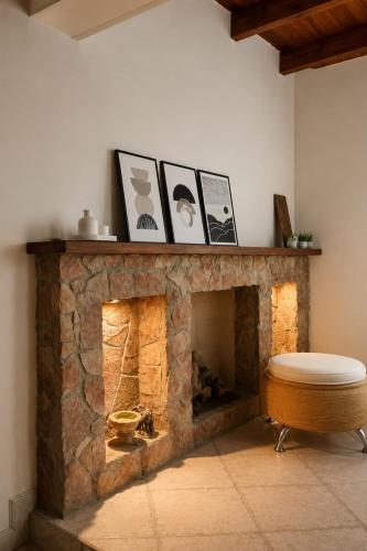 a living room with a stone fireplace with a stool at Caelum House Familiar Con Cochera in Rafaela