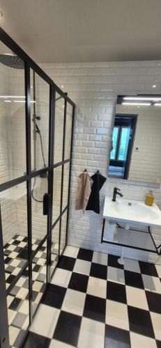 a bathroom with a white sink and a checkered floor at Hotelli Pato in Nakkila