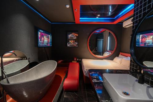 a room with a tub and a bed and a tv at Benri Hotel Signature in Ho Chi Minh City