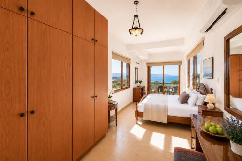 a bedroom with a bed and some windows at Villa Argaka Heights in Argaka