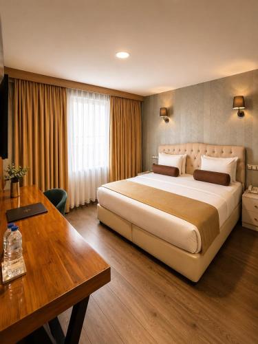 a hotel room with a large bed and a desk at Kuzen Otel in Istanbul