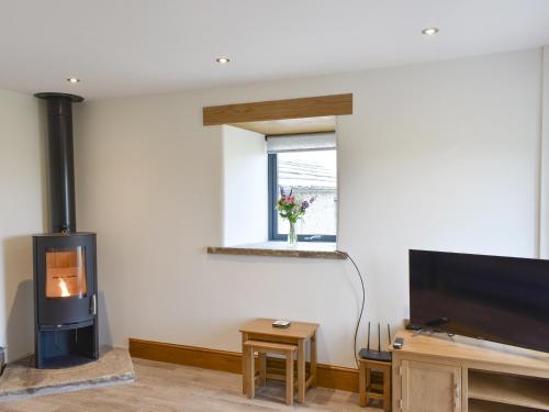 a living room with a fireplace and a flat screen tv at Deer Park Barn - Uk33323 in Reeth