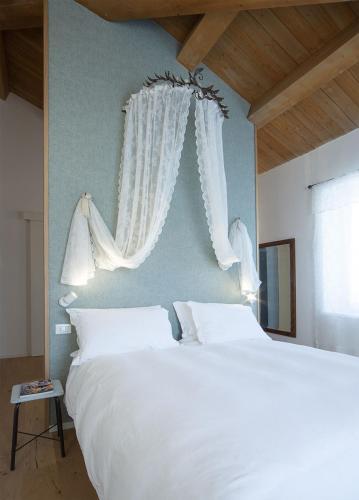 a bedroom with a large white bed and a window at Agriturismo Casacarella in Cesena