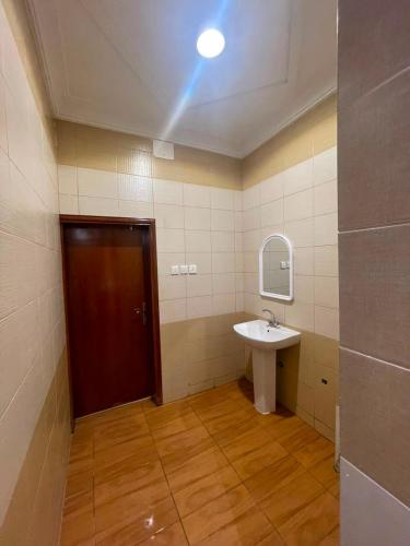a bathroom with a sink and a brown door at شقق jm احد رفيدة 2 in Ahad Rafidah