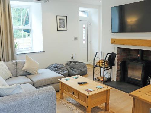 a living room with a couch and a fireplace at Gate House in Llangefni