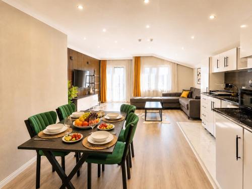 a kitchen and living room with a table and green chairs at Casa Florya Suites in Istanbul