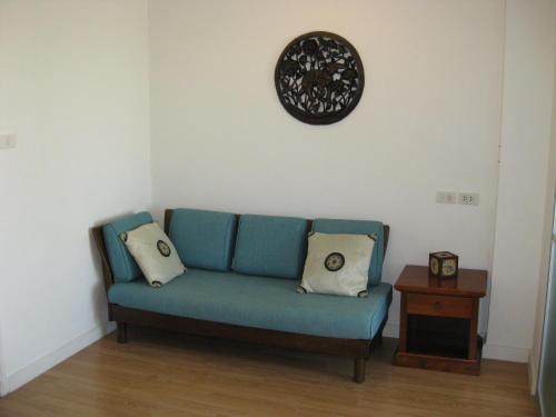 a blue couch in a room with a clock on the wall at Bangkok view in Pinklao in Bangkok