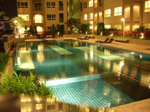 a swimming pool in the middle of a building at night at Bangkok view in Pinklao in Bangkok