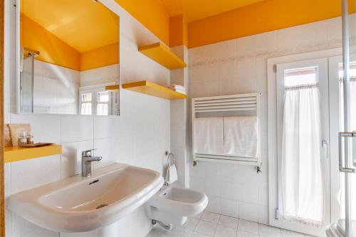 ein weißes Badezimmer mit Waschbecken und Toilette in der Unterkunft Hotel EMI in Calderara di Reno