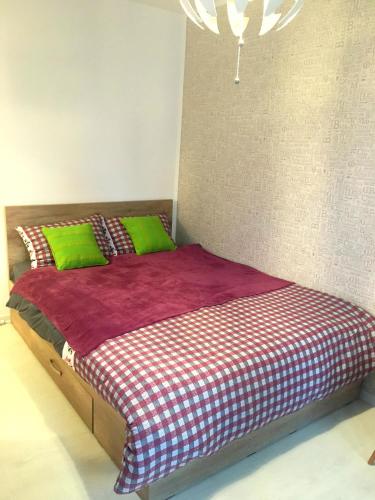 a bedroom with a bed with green and red sheets at Amy's Studio in Bucharest