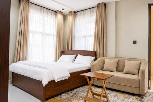 a bedroom with a bed and a couch and a chair at NioneEdge-Arusha-Moshono in Themi
