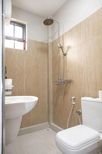 a bathroom with a shower and a toilet and a sink at NioneEdge-Arusha-Moshono in Themi