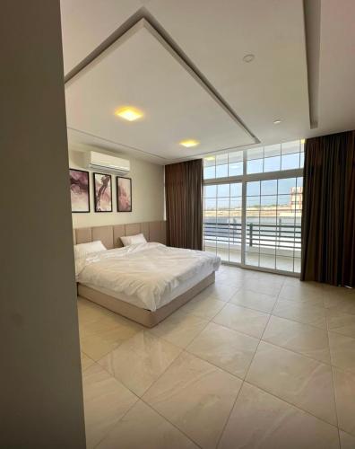 a bedroom with a large bed and a large window at Diva Chalet in Sowayma