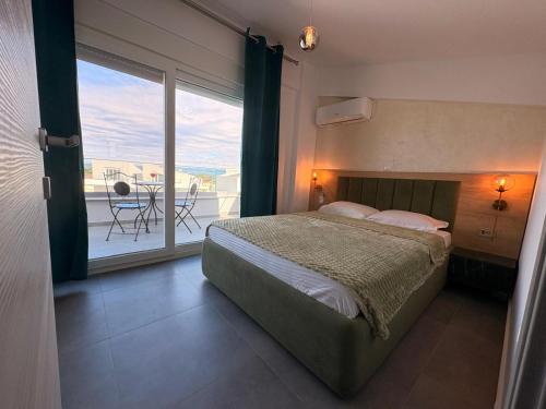 a bedroom with a bed and a view of a balcony at Viasol Suites Thassos in Skala Rachoniou