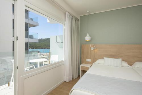 a bedroom with a bed and a large window at HSM Regana - Adults Only in Cala Ratjada