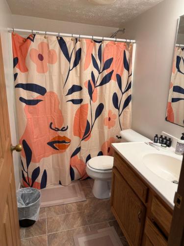 ein Badezimmer mit Toilette und Duschvorhang in der Unterkunft The Wright Stay in Dayton