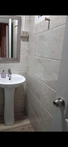 a bathroom with a white sink and a mirror at Hotel Centro in Copiapó