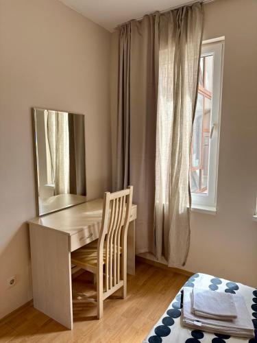 a bedroom with a desk and a mirror and a window at Apartment Amelia in Rogachevo
